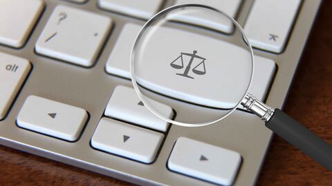 Auf einer Computertastatur ist auf der Shift-Taste die Waage der Justitia abgebildet. Die Taste wird durch eine Lupe vergrößert.  